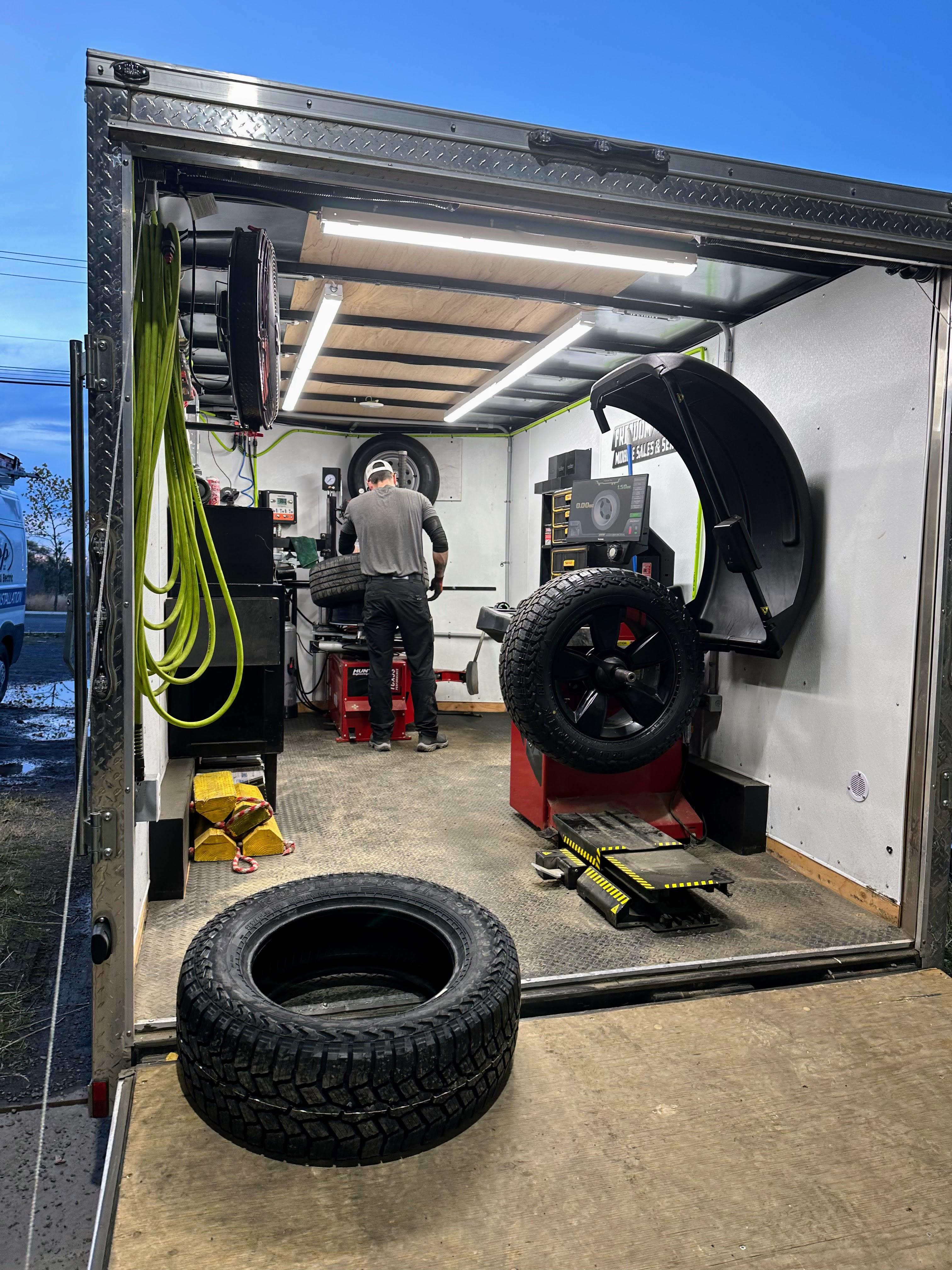 View into Freedom Tires mobile trailer showing professional professional balancer and full equipment layout