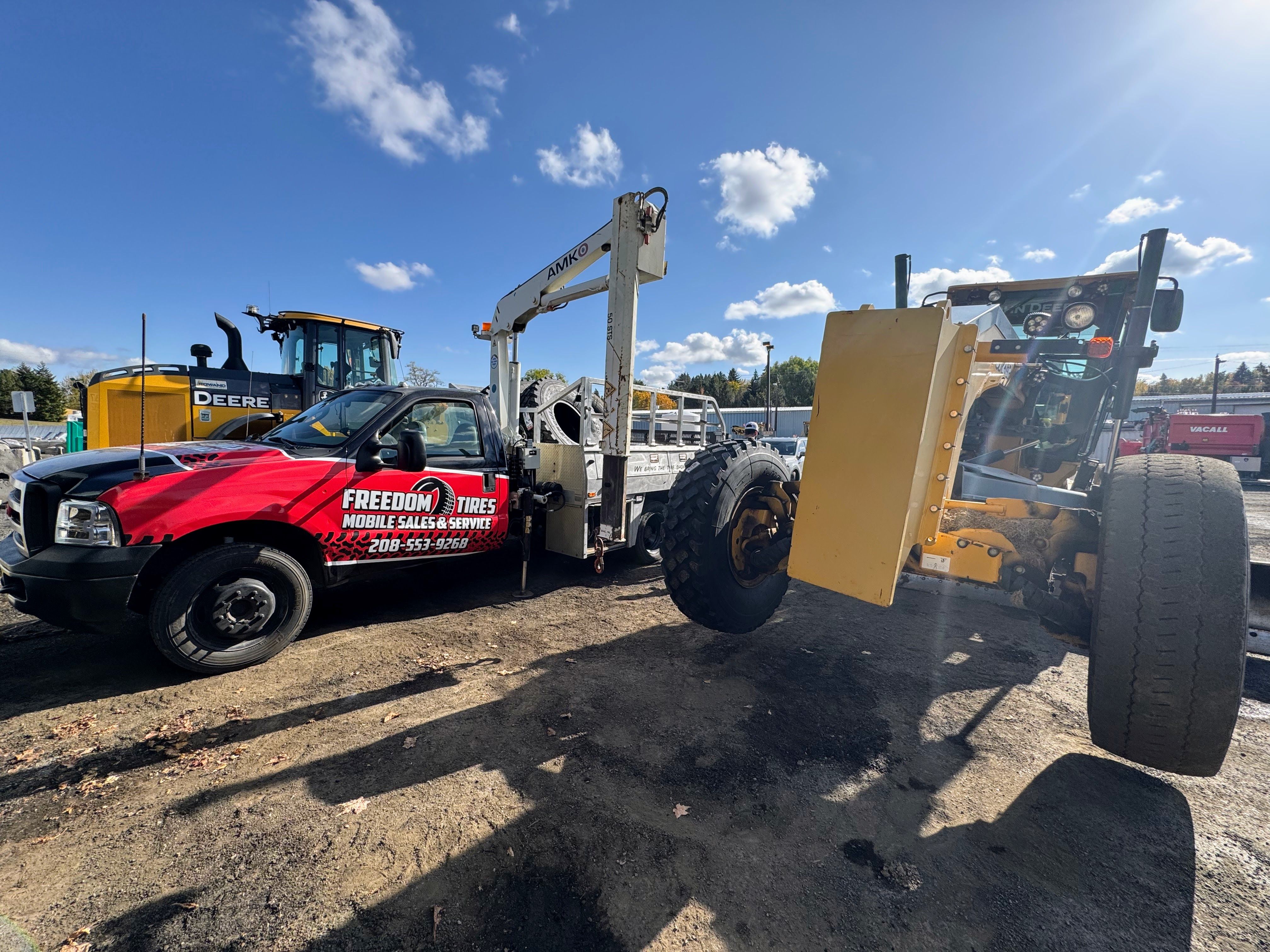 Freedom Tires service truck at heavy equipment yard with John Deere machinery